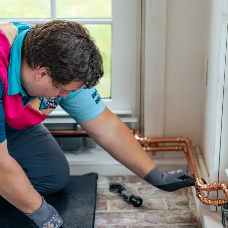 A picture of Clake working on home plumbing in NH